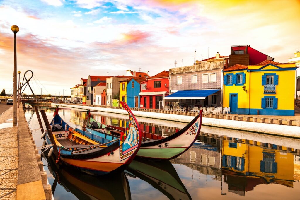 Colourful moliceiros boats and houses along the canal at sunset for Aveiro cannabis travel guide CannaTrailz