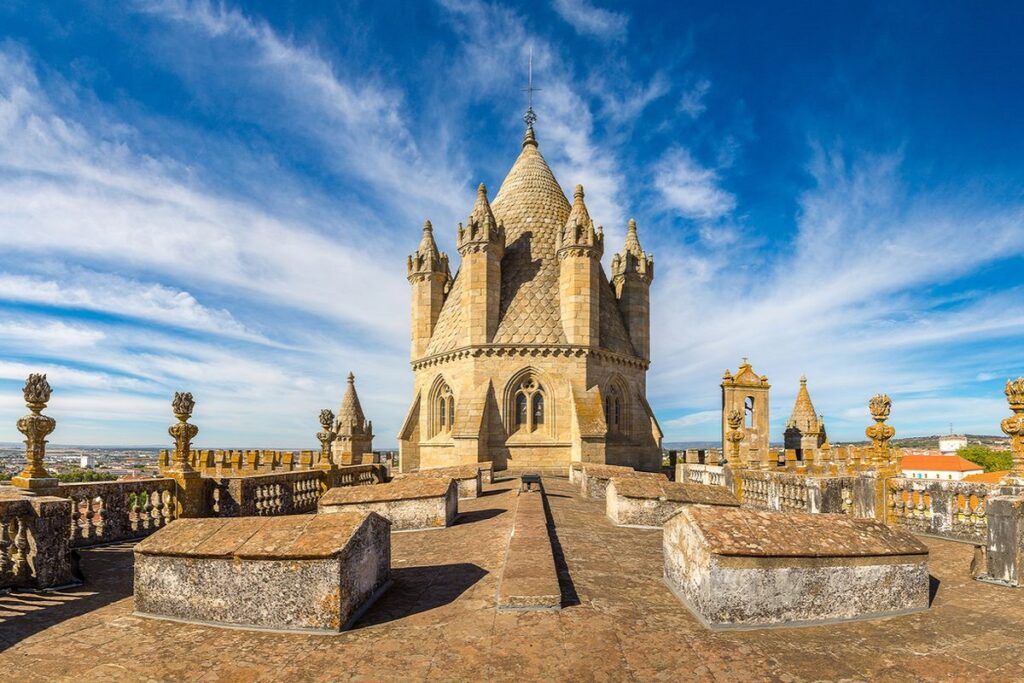 Rooftop terrace view of the Evora cathedral on a sunny day with blue sky and white clouds for Evora cannabis travel guide CannaTrailz