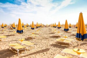 Yellow umbrellas on sandy lido for cannabis in Jesolo travel guide cannatrailz