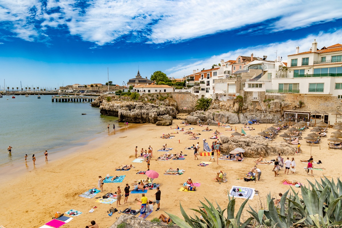 A packed Praia da Rainha on a sunny summer day for Cascais cannabis travel guide CannaTrailz