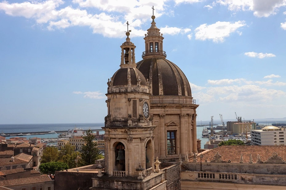 Cityscape view of the Cathedral dome on a sunny day with blue clouds in Catania, Sicily, Italy.