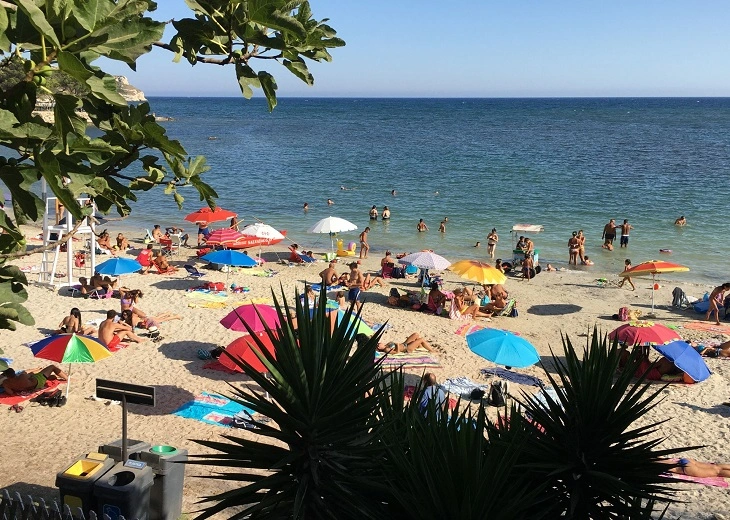 Bustling crowd t Poetto beach makes it a favorite spot for cannabis in Cagliari relaxation.