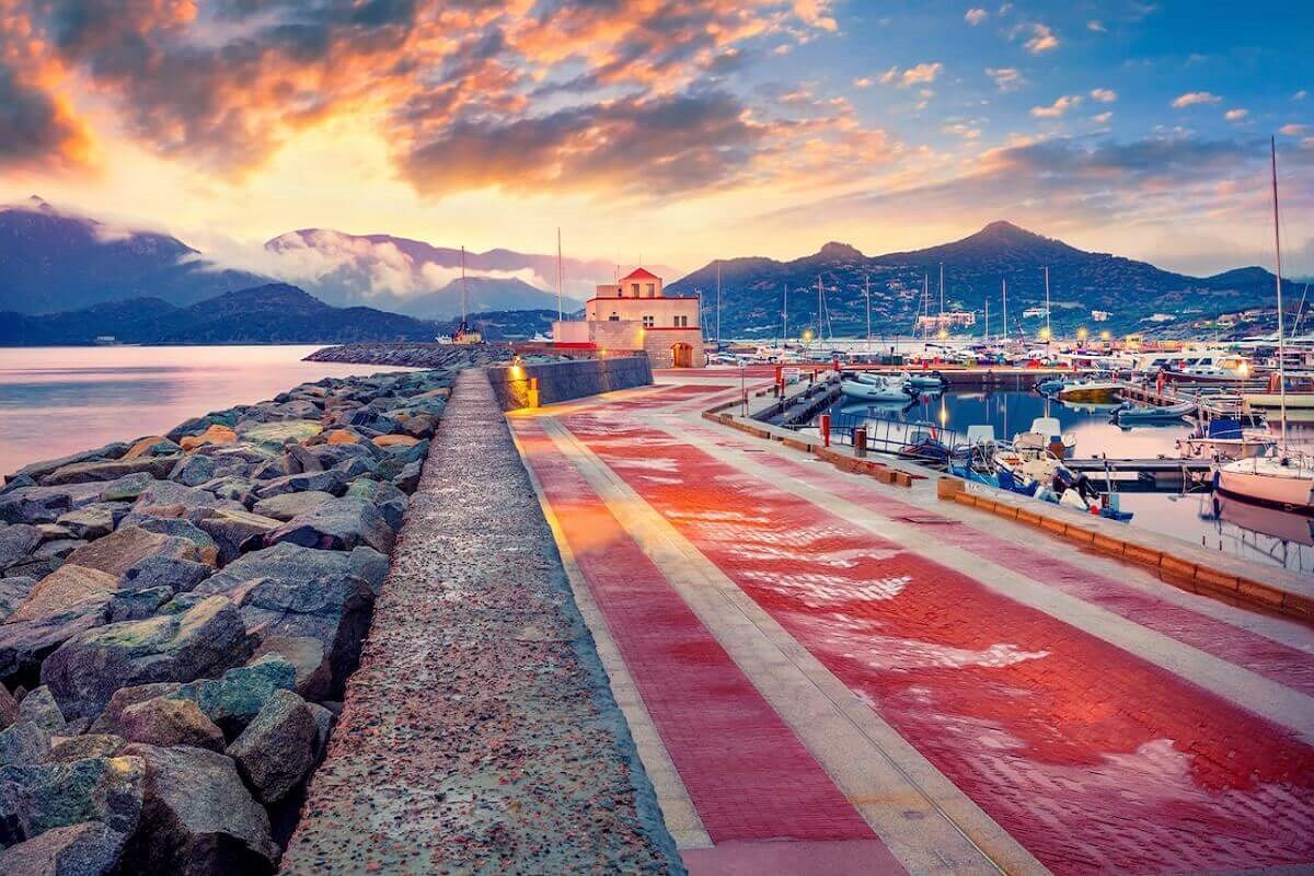 The marina promenade tourist harbor of Villasimius at subset in Sardinia, Italy.