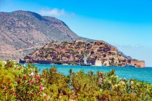 Cross-sea view of the Crete Island with turquoise waters and vegetation.