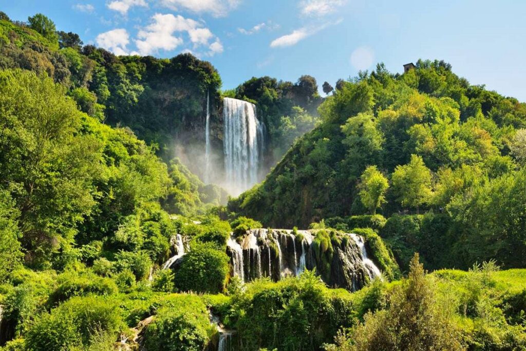 Lush green landscape with cascading waterfalls for Cannabis in Umbria Travel Guide.