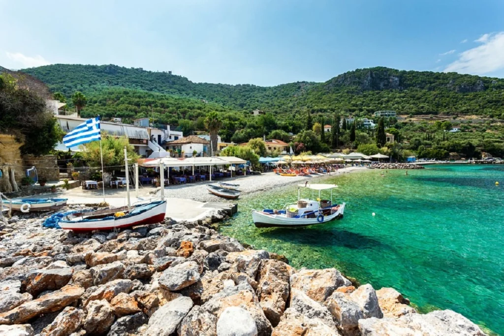 Scenic beach with boats and greenery on the coast of Kalamata in Greece.