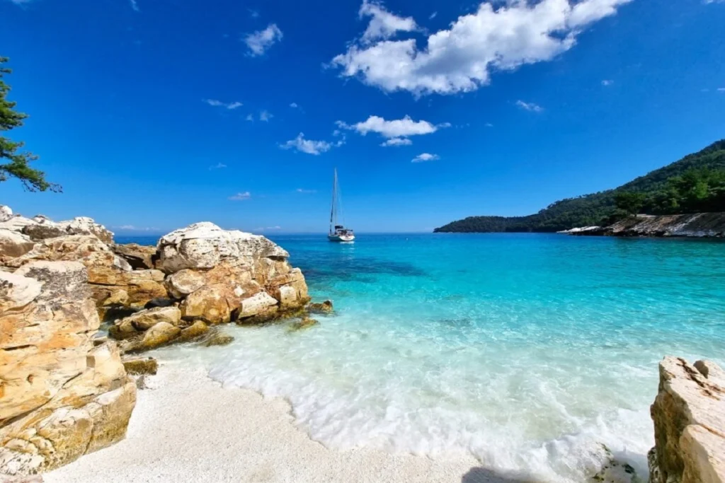 A marble beach with turquoise waters on Thassos Island, Greece.