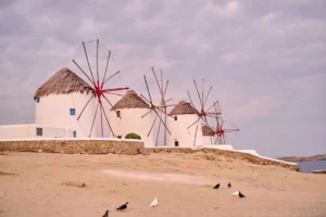 The three iconic whitewashed windmills under ambient sky in Mykonos Island, Greece.